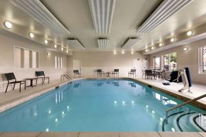 阿林顿达拉斯-阿灵顿希尔顿霍姆伍德套房酒店的一个带桌椅的大型游泳池