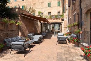 蒙特罗尼德阿尔比亚Hotel Ristorante Borgo Antico的砖砌人行道上的一组桌椅