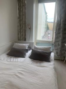 赫尔辛基Idas AirBnB的窗户前的一张带两个枕头的床
