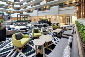 亚特兰大Embassy Suites by Hilton Atlanta Perimeter Center的大堂,设有桌椅