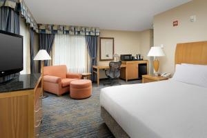 亚基马Hilton Garden Inn Yakima Downtown的酒店客房配有一张床、一张书桌和一台电视。