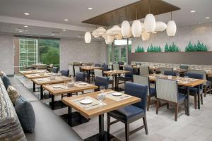Dobbs Ferry多布斯费里威彻斯特希尔顿花园酒店的餐厅设有木桌和蓝色椅子