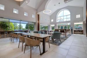 兰斯代尔兰斯代尔希尔顿惠庭套房酒店的用餐室设有桌椅和窗户。