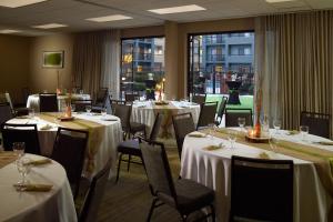 亚特兰大普瑞米尔中心万怡酒店的餐厅配有桌椅和白色的桌布