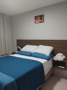 若昂佩索阿Flat Jardins do Atlântico, frente mar的一间卧室配有一张带蓝色床单的大床