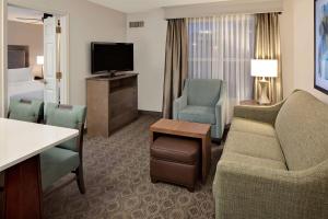 布卢明顿Homewood Suites by Hilton Minneapolis-Mall Of America的酒店客房设有沙发、椅子和电视。