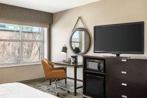 波特兰波特兰市中心水滨汉普顿酒店的一间卧室配有电视、书桌和椅子