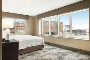 波特兰波特兰市中心水滨汉普顿酒店的一间大卧室,配有一张床和一个大窗户