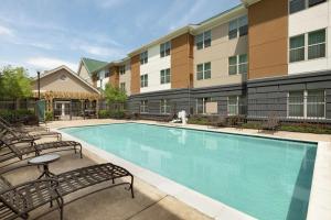 阿什本Homewood Suites by Hilton Dulles-North Loudoun的一座带椅子的游泳池以及一座建筑