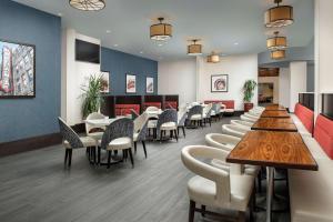 胡佛Embassy Suites by Hilton Birmingham Hoover的餐厅内带桌椅的等候室
