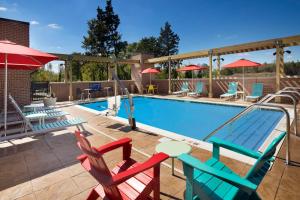 默夫里斯伯勒Home2 Suites By Hilton Murfreesboro的游泳池配有五颜六色的椅子和桌椅