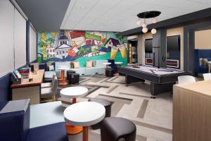 塔拉哈西Tru By Hilton Tallahassee Central的一间设有乒乓球桌和壁画的房间