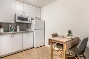 迈尔斯堡InTown Suites Extended Stay Fort Myers FL的厨房配有桌子和白色冰箱。
