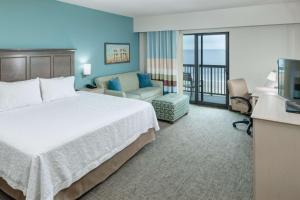 卡罗来纳比奇希尔顿卡罗莱纳州海滨汉普顿酒店 的酒店客房设有一张床和一个阳台。
