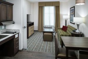 卡纳维拉尔角卡纳维拉尔角-可可比奇希尔顿惠庭套房酒店的酒店客房设有沙发和客厅。