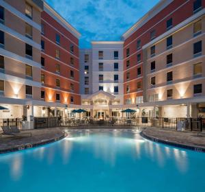 卡纳维拉尔角Hampton Inn & Suites Cape Canaveral Cruise Port, Fl的夜间酒店庭院的游泳池