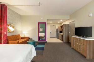 斯泰茨伯勒Home2 Suites By Hilton Statesboro的配有一张床和一台平面电视的酒店客房
