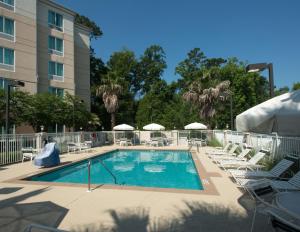 塔拉哈西塔拉哈西中央希尔顿花园酒店的一个带椅子和滑梯的酒店游泳池