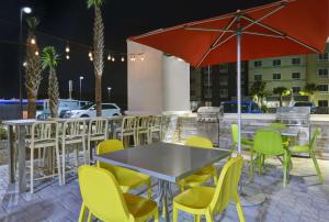 巴拿马城海滩Home2 Suites By Hilton Panama City Beach, Fl的庭院里配有桌椅和遮阳伞