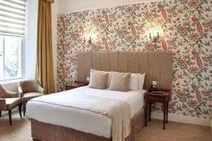 皮特洛赫里艾瑟尔宫酒店的一间卧室配有一张带花卉壁纸的大床