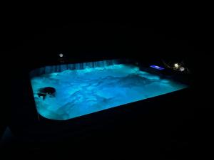 于斯塔里茨LES CHAMBRES D'ARRAUNTZ的在黑暗的房间里,在蓝色的浴缸里游泳的人
