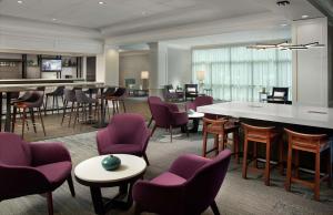 亚特兰大Hilton Garden Inn Atlanta-Buckhead的大堂设有紫色桌椅和酒吧