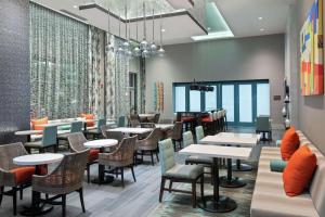 亚特兰大Hampton Inn & Suites Atlanta Buckhead Place的用餐室设有桌椅和窗户。