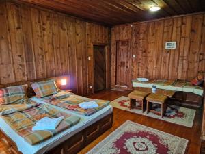 泽拉夫纳Къща за гости Никула Чорбаджи的一间设有两张床和一张桌子的房间