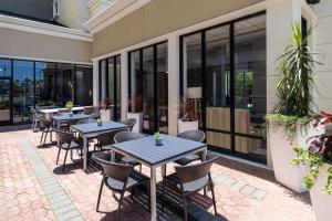 庞特韦德拉比奇杰克逊维尔/蓬特韦德拉希尔顿花园酒店的户外庭院设有桌椅和窗户。