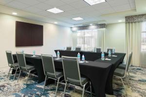 坦帕Homewood Suites by Hilton酒店坦帕机场 - 西岸的一间会议室,配有桌椅和屏幕