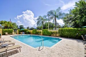 棕榈滩花园棕榈滩花园汉普顿旅馆的一个带庭院家具和树木的游泳池