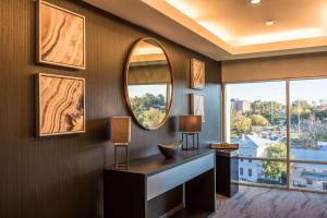 塔拉哈西Hampton Inn & Suites Tallahassee Capitol-University的客房设有镜子、书桌和窗户。
