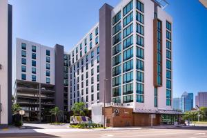坦帕Home2 Suites By Hilton Tampa Downtown Channel District的城市街道上一座高大的白色建筑,窗户