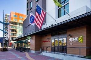 坦帕Home2 Suites By Hilton Tampa Downtown Channel District的悬挂在建筑物一边的两面美国国旗