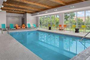 萨默维尔Home2 Suites By Hilton Summerville的游泳池配有五颜六色的桌椅