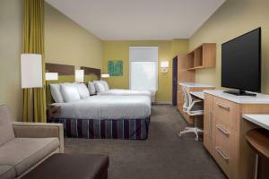 萨默维尔Home2 Suites By Hilton Summerville的配有一张床和一台平面电视的酒店客房