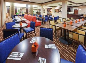 米德兰米德兰希尔顿花园酒店 的一间配备有桌子和蓝色椅子的用餐室