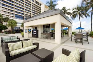 迈阿密迈阿密机场蓝色泻湖希尔顿酒店的一座带桌椅的庭院和一座建筑