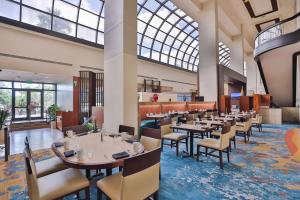 迈阿密迈阿密机场蓝色泻湖希尔顿酒店的餐厅设有桌椅和大窗户。