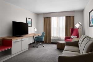 博福特博福特希尔顿花园酒店的客厅配有电视、沙发和椅子