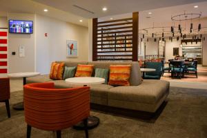 路易斯威尔Hilton Garden Inn Louisville Mall Of St. Matthews的客厅配有沙发和桌椅