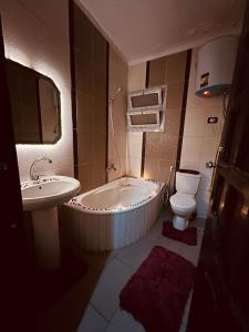开罗Momen Pyramids Inn的带浴缸、卫生间和盥洗盆的浴室