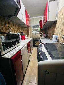 开罗Momen Pyramids Inn的一间厨房,里面装有红色橱柜和一辆汽车