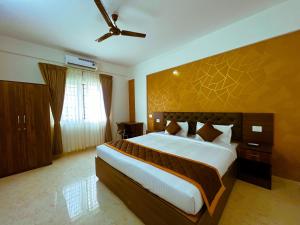 班加罗尔Sai Bliss International, Bangalore的一间卧室配有一张大床和吊扇