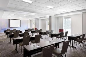 森特尼尔丹佛南公园梅多斯区希尔顿花园酒店的一间会议室,配有桌椅和屏幕