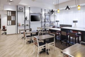 凤凰城Hampton Inn & Suites Phoenix Downtown的餐厅设有桌椅和平面电视。