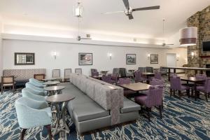 劳雷尔山劳雷尔山希尔顿惠庭套房酒店的餐厅设有紫色的桌椅和沙发