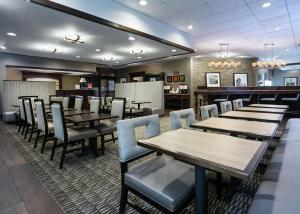匹兹堡Hampton Inn Pittsburgh University Medical Center的一间带桌椅的餐厅和一间酒吧