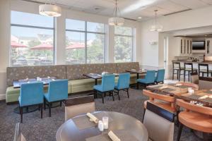 萨凡纳萨凡纳机场希尔顿花园酒店的用餐室设有桌椅和窗户。