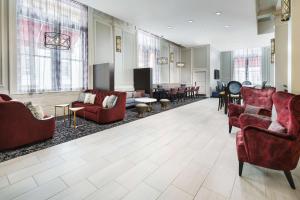 巴尔的摩巴尔的摩内港希尔顿恒庭旅馆&套房酒店的一间带红色椅子的客厅和一间带桌子的客厅